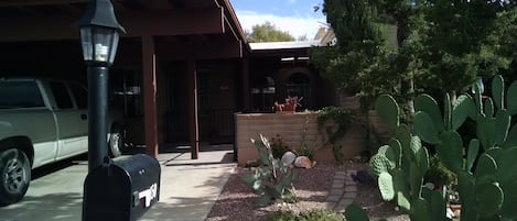 Two car carport in front with landscaped yard.