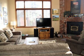 Mammoth Lakes Condo Rental Woodlands 48 - Comfortable Living Room with Woodstove Access to Outdoor Deck