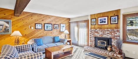 Living room with a wood burning fireplace and access to the deck