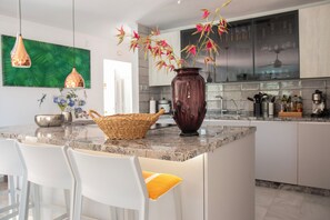 Tropical artisan prints and exotic floral displays create a vibrant atmosphere.