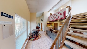 View from entry showing stairs to loft as well as living room and seating areas.