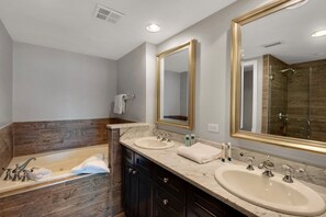 Master bathroom with dual vanities, jetted tub, and walk-in shower. 