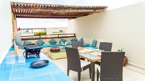 Exclusive rooftop outdoor dining and lounge area with grill.