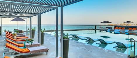 Terraza con solarium, piscina y jacuzzi con vista al mar y la ciudad amurallada.