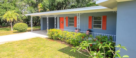 Front porch and carport of home on 2 city lots.