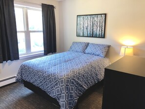 Bright second bedroom with double bed, 2 nightstands, one chest and a closet. 