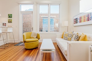 The Daily Condo 201 at 120 College Street in the Asheville Times Building. The living area adjoins the kitchen area and counter, next to the outdoor private terrace. 