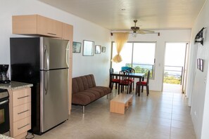 Full kitchen and dining area, looking out towards balcony.