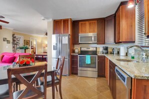The beautiful kitchen features granite counters, custom cabinets, and full size stainless steel appliances.