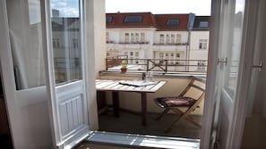 Balcony with a view to trees, cafés, restaurants.