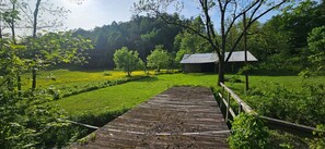 The barn with horses in the field.
