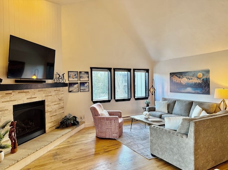 Living room with vaulted ceiling, fire place, 65" TV and beautiful views.
