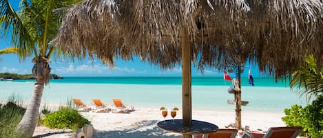 Beachfront palapa with lounge chairs