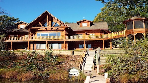 Front of House facing the lake with dock and fishing boat
