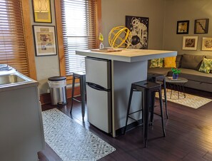 The apartment-size fridge is under the island.