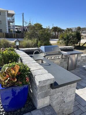 New Outdoor Kitchen featuring a grill, large burner, sink, and refrigerator.