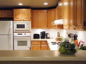 Large kitchen with wall oven, microwave, full size fridge, 4 burner countertop.
