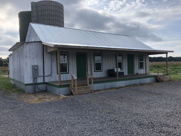 front view. Shipping container covered in reclaimed wood, big porch, cool house!