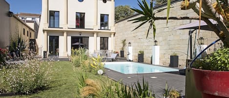 La villa, son jardin fleuri ensoleillé et la piscine chauffée