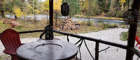 view of river from front porch with cozy fire table for relaxing.