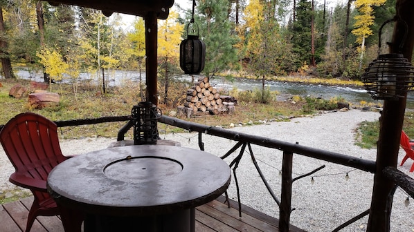 view of river from front porch with cozy fire table for relaxing.