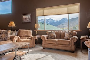 Livingroom with full size sofa, loveseat, reclining chair, 65" flat screen TV.