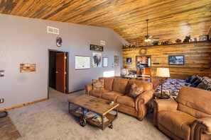 Large livingroom with vaulted ceilings, love seat, couch and recliner.