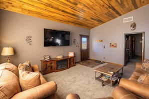Large livingroom with couch, loveseat, recliner and 65" flat screen TV.