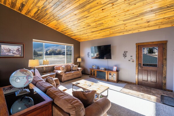Large livingroom with couch, loveseat, recliner and 65" flat screen TV.