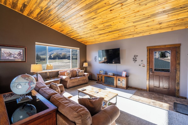 Large livingroom with couch, loveseat, recliner and 65" flat screen TV.