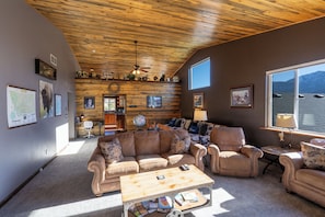 Large livingroom with couch, loveseat, recliner and vaulted ceiling.