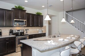 Fully equipped kitchen with modern appliances and a large island for family gatherings.