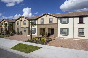 Charming Exterior: Welcome to your vacation retreat! This stunning two-story townhome features a modern facade, private driveway, and lush surroundings, setting the tone for an unforgettable stay.