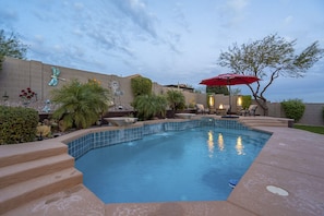 Heated pool with an attached spa, water features, and pool decks on either side.