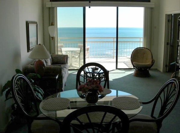 Looking from kitchen through living room to front balcony & ocean in backround