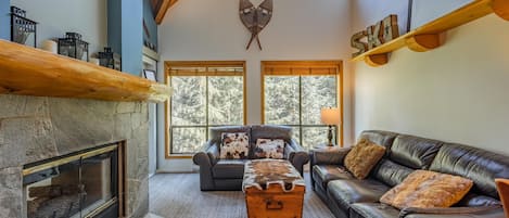 Spacious living area with high ceiling, gas fireplace, and smart TV.