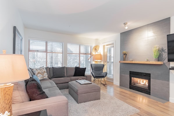 Spacious living area with a gas fireplace, TV and double-size murphy bed.