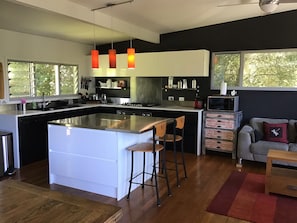 Chefs kitchen with stainless island bench with breakfast bar