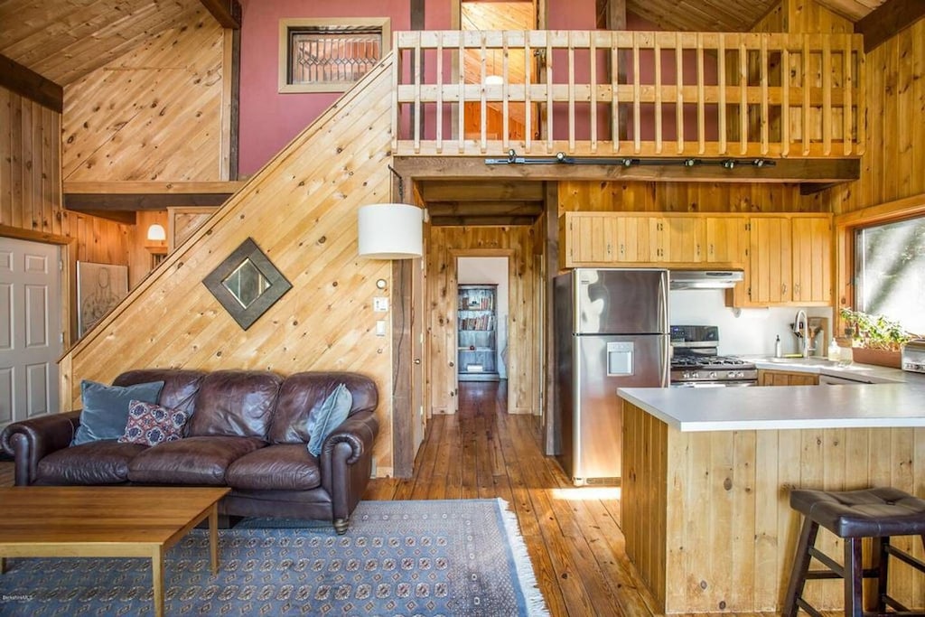 Interior of modern kitchen, couch, and loft in one of the best cabin rentals in Massachusetts.
