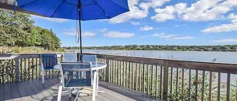 porch overlooking cove with table, chairs and umbrella