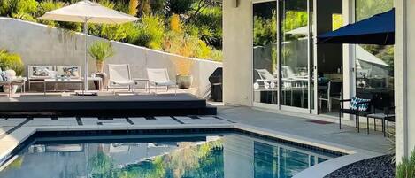 View of pool, deck and partial view of house. 

