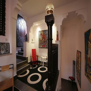 Living area with ancient columns, arches and mid 20th century classic furniture