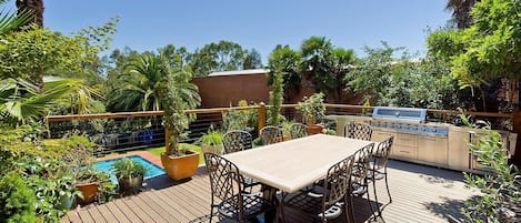 Gorgeous balcony with barbecue and outdoor dining looking over the pool