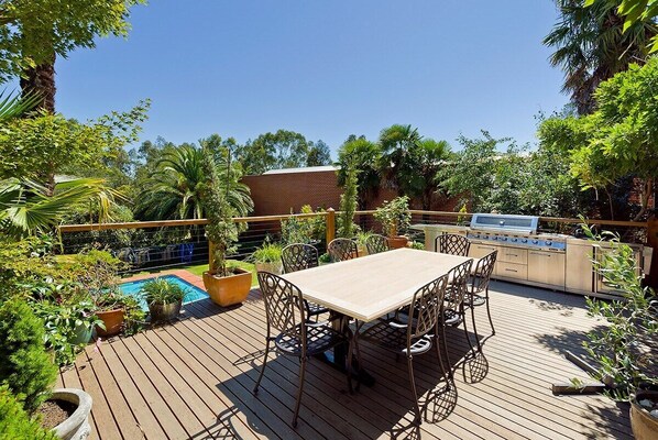 Gorgeous balcony with barbecue and outdoor dining looking over the pool