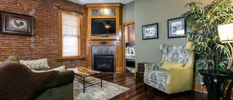 Living room featuring gas fireplace, pull out couch and tv.