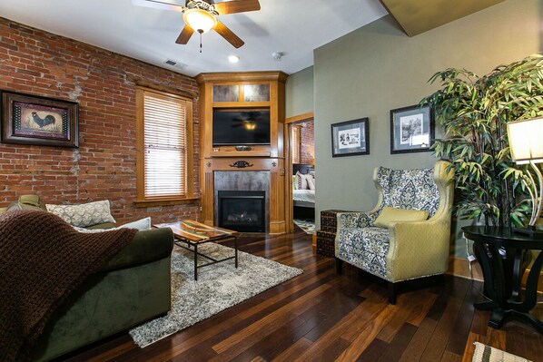 Living room featuring gas fireplace, pull out couch and tv.
