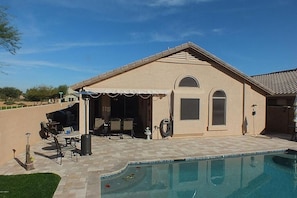 View of house from pool area. Fully tiled backyard with travertine pavers.