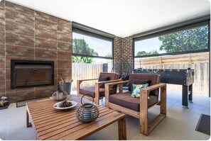 Alfresco area with Outdoor Wood fireplace, seating & soccer games table
