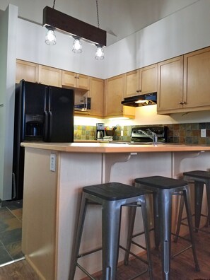 4 barstools allow people to interact with whoever is in the kitchen