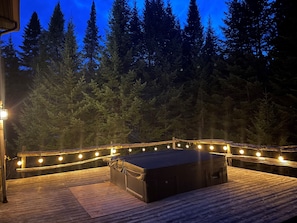 Hot tub area with outdoor lighting